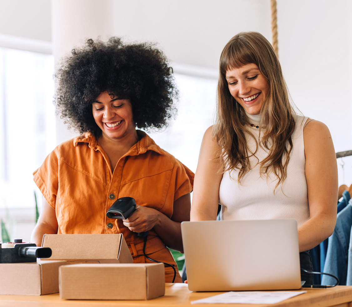 Twee jonge vrouwen scannen lachend een pakketje