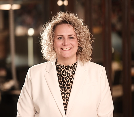 Vrouw kijkt lachend in de camera met op de achtergrond de Persoonality vestiging